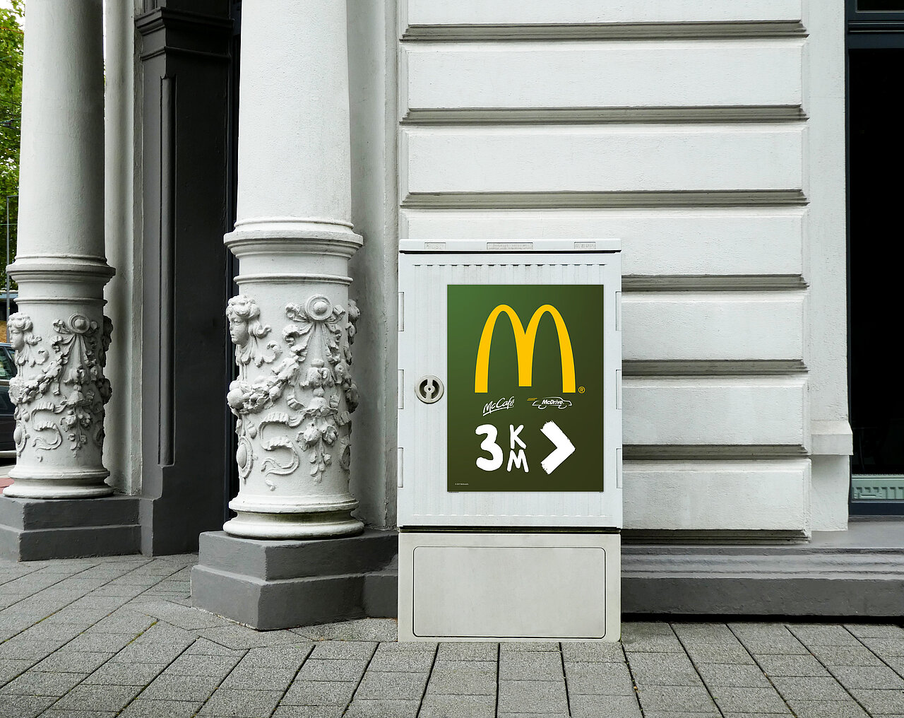 City Cube mit McDonalds Logo und Aufschrift "3km" für eine dauerhafte Außenwerbung mit einer Laufzeit von 12 Monaten. Ideal für lokale Werbung an gut sichtbaren Standorten.