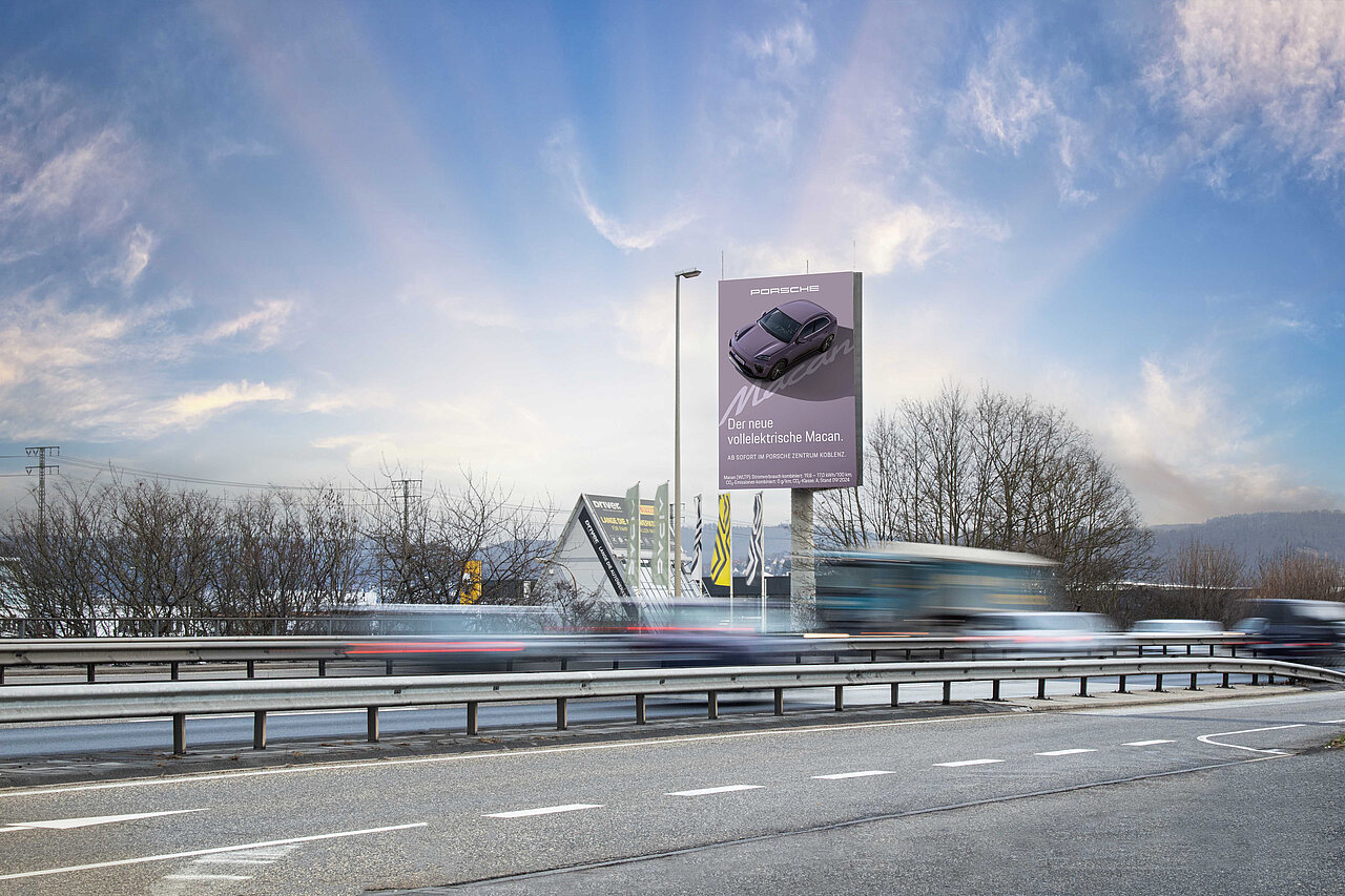 Digitale Großfläche an der B9 in Koblenz bei Tageslicht und hohem Verkehrsaufkommen mit Werbe-Motiv von Porsche..