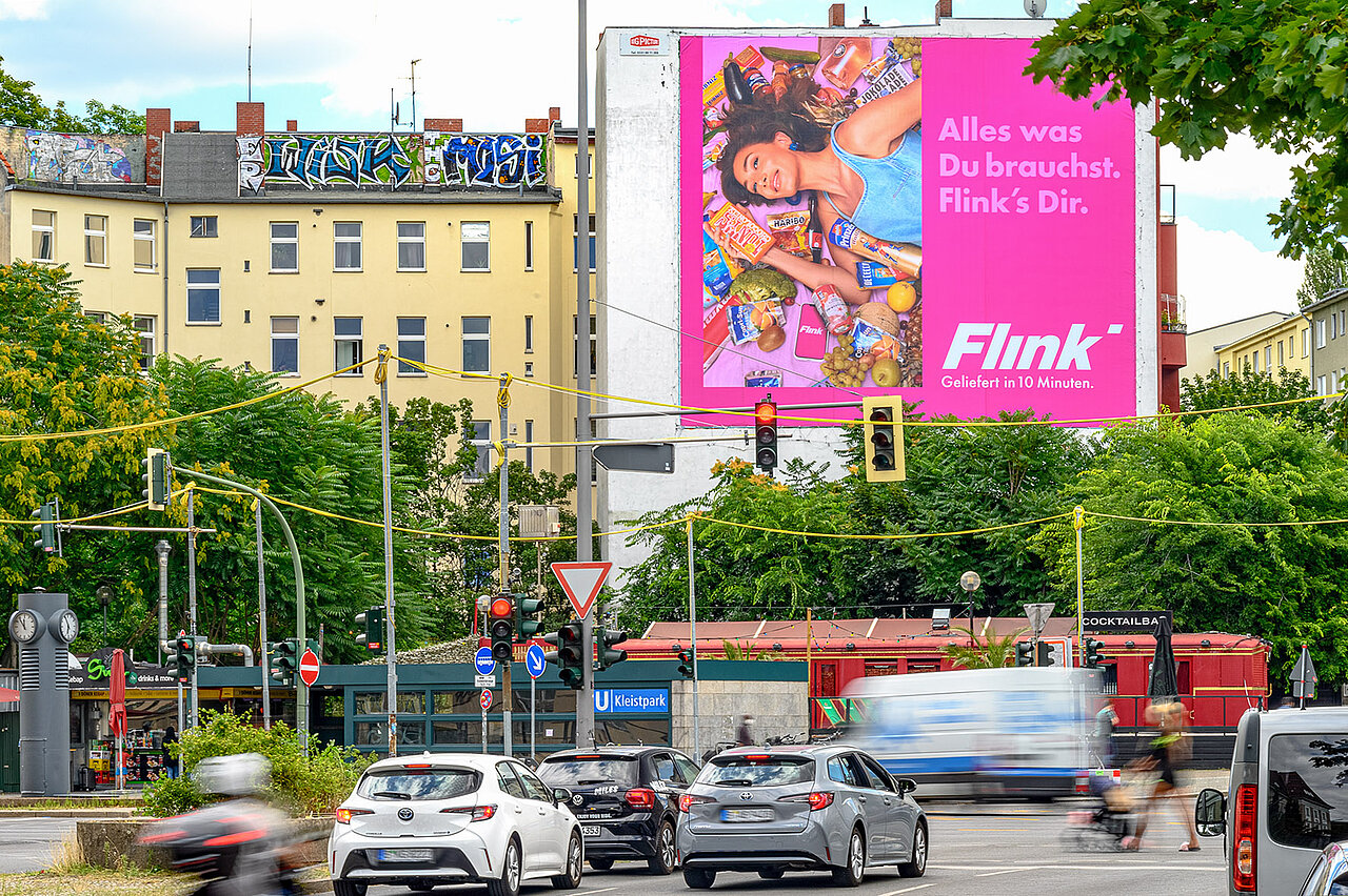 Das Riesenposter von „Flink“ zieht mit leuchtendem Pink und dem Slogan „Alles was Du brauchst. Flink’s Dir.“ alle Blicke auf sich.