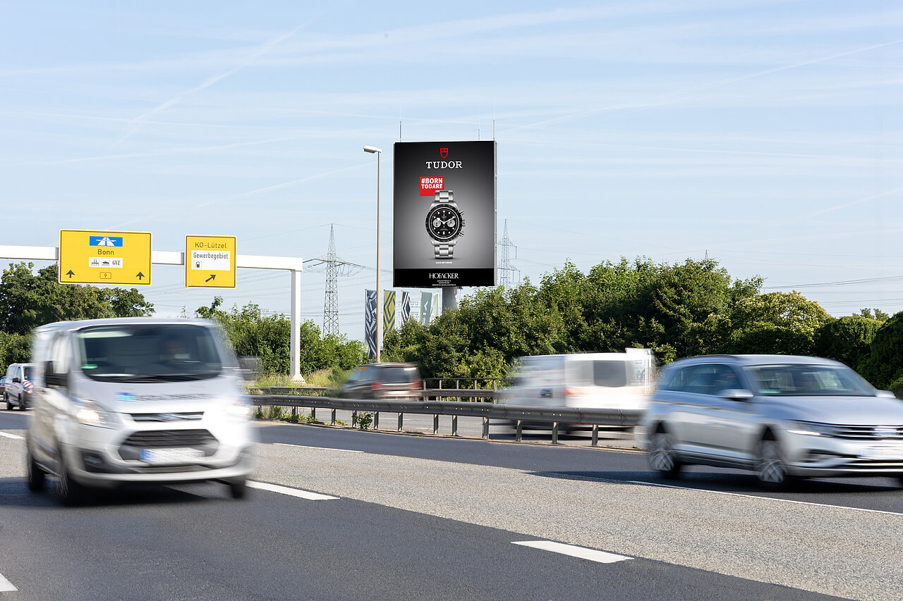Digital Tower in Koblenz an der B9 bei starker Verkehrslage bei Tag. Motiv einer Uhr vom Juwelier Hofacker. 