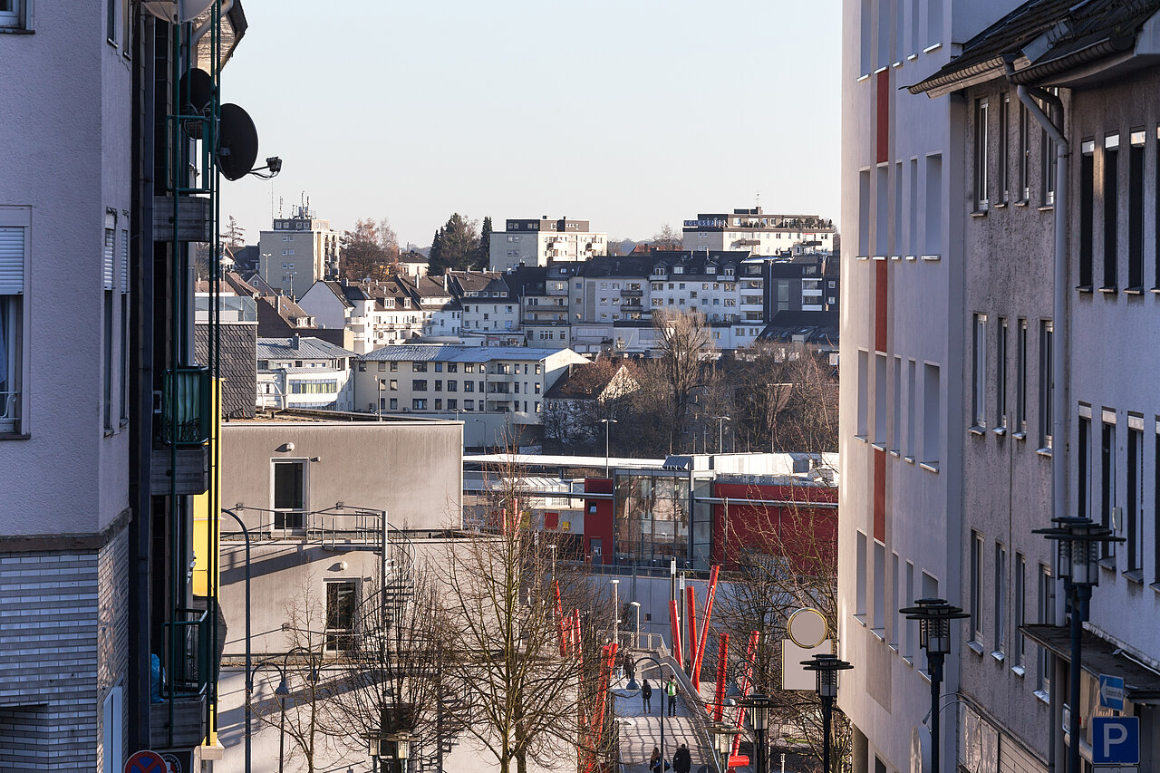 Das Bild zeigt eine Gasse in Remscheid mit Blick auf die Fußgängerbrücke am Hauptbahnhof.
