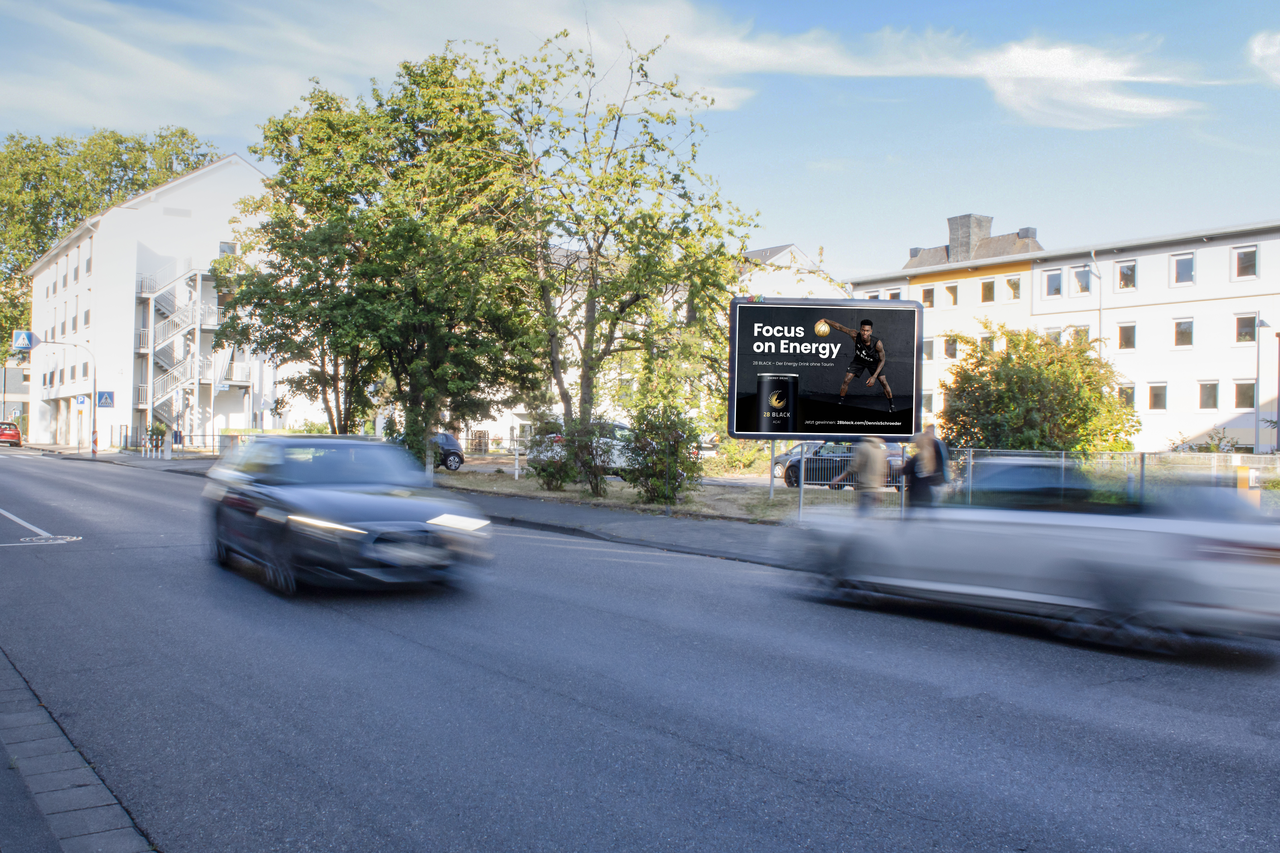 Befahrene Straße mit Sicht auf ein Großplakat von der Marke 28BLACK.