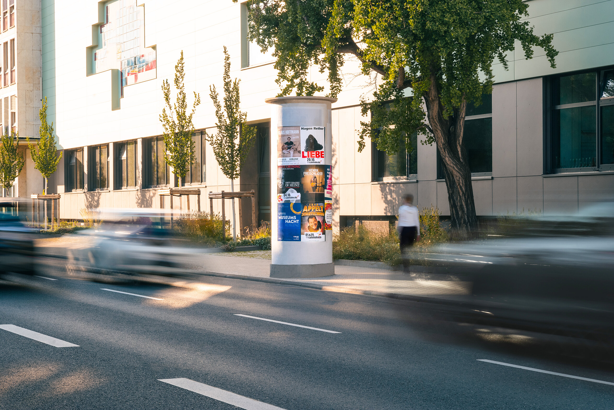 Medium Allgemeinstelle mit vielen Postern an befahrender Straße