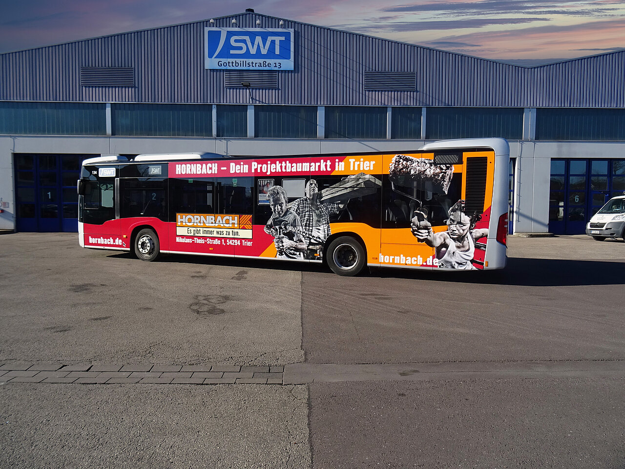 Buswerbung mit Hornbach-Motiv auf Normalbus vor der Lagerhalle der Stadtwerke Trier