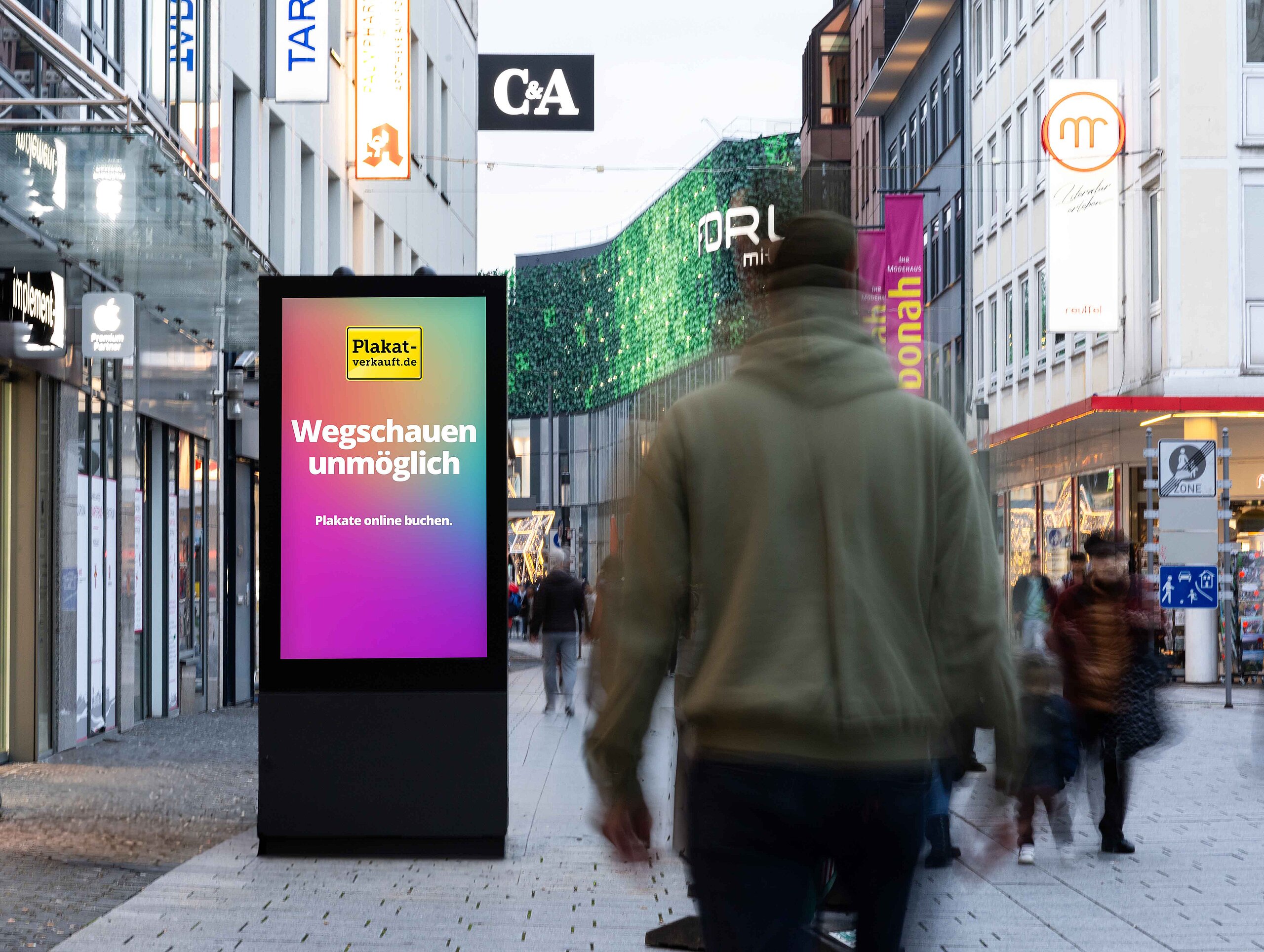 Digitales Citylight-Poster in einer belebten Innenstadt an einer Kreuzung.