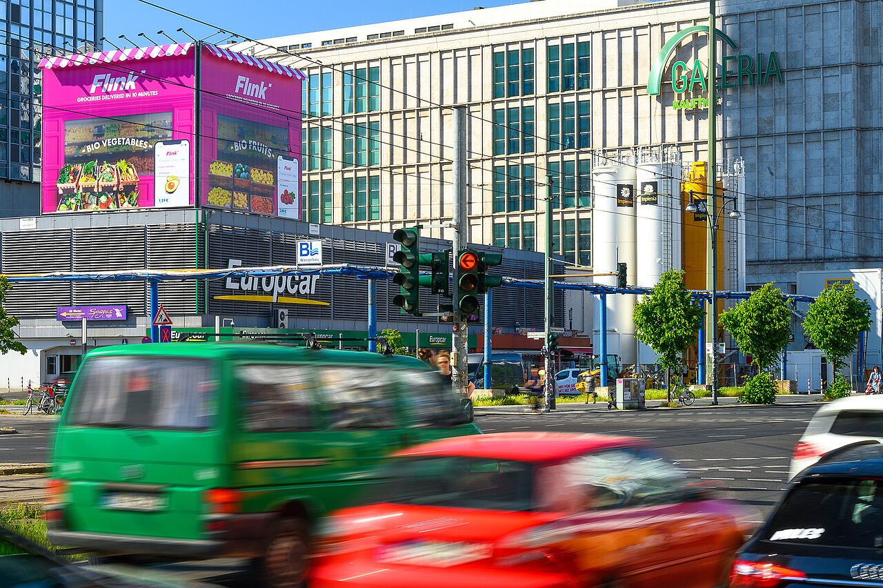 plakat-verkauft.de_Riesenposter_flink_Berlin-Park Das auffällige Riesenposter von Flink über dem Europcar-Gebäude bewirbt Bio-Lebensmittel und schnellen Lieferservice in leuchtendem Pink.