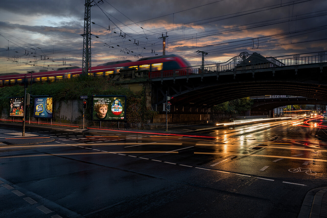 Drei Großplakate am Straßenrand in Bahnhofsnähe.