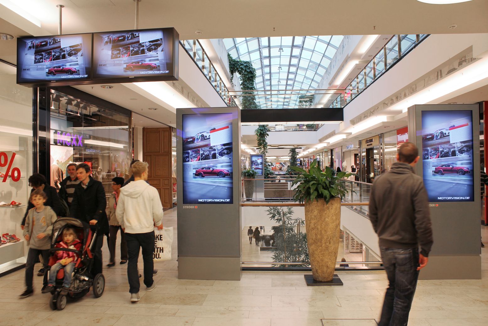 Vier digitale Screens im Einkaufszentrum mit Motiven von Motorvision.de.