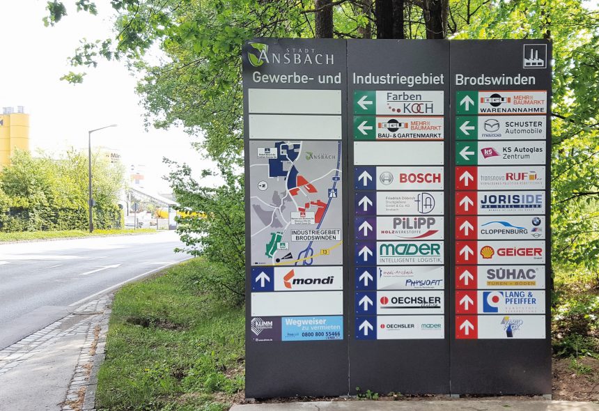 Hinweisschild im Gewerbegebiet mit Richtungsangaben zu Unternehmen wie Bosch, Farben Koch und weiteren Firmen. Ideal für die Orientierung von Besuchern.